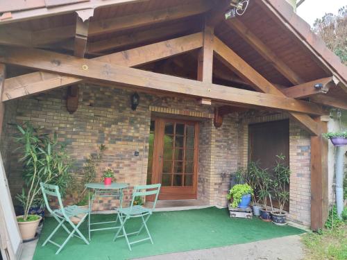 a patio with a table and chairs and a wooden roof at Chambres d'hôtes Hébergement F.Mathieu in Saint-Maurice-sur-Moselle