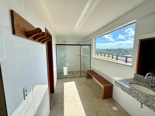 een badkamer met douche, wastafel en raam bij Apartamento com Área de Lazer na Cobertura in Cururupe