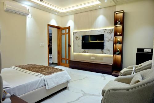 a bedroom with a bed and a flat screen tv at FLORENTINO The Luxury Villa in Amritsar