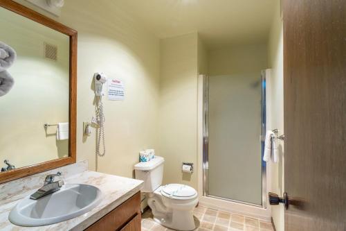 une salle de bain avec un lavabo, des toilettes et un miroir dans l'établissement Anchor Lodge, à Fort Bragg