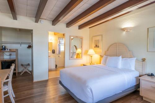 une chambre avec un grand lit blanc et un bureau dans l'établissement Anchor Lodge, à Fort Bragg