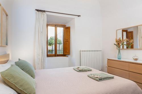 Un dormitorio con una cama con dos toallas encima. en Il Cantuccio di Vittorio - Apartment with private garden in the Heart of Volterra, en Volterra