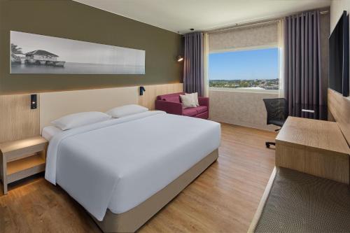 达沃市达沃丽柏酒店的卧室里有一张白色的大床和一张书桌