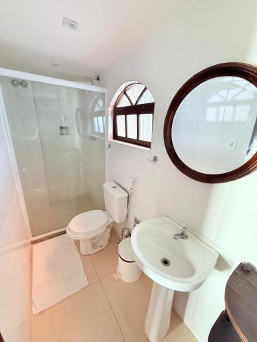 a bathroom with a toilet sink and a mirror at Pousada Vó Nina in Arraial do Cabo