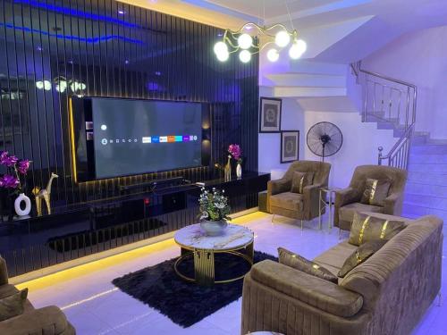 Una sala de estar con un sofá y un televisor en Beautiful peaceful comfortable, en Lekki