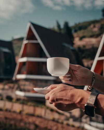 een persoon die een kopje voor een huis vasthoudt bij Kitonga Garden Resort in Kangundo