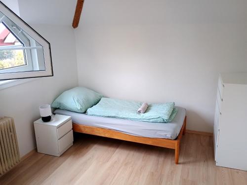 a small bed in a room with a window at Ubytování nad kostelem in Prague