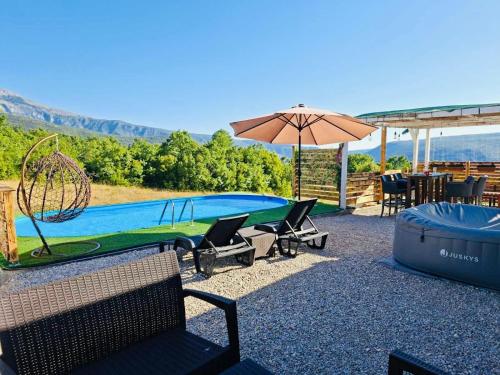 a pool with chairs and an umbrella and a table at Villa Aura Of Calm in Mostar