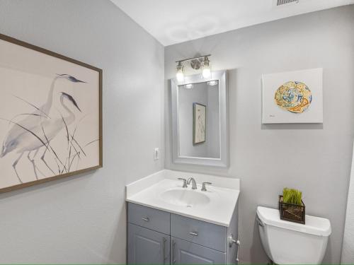 ナバーにあるMermaid Manorの洗面台、トイレ、鏡のあるバスルーム