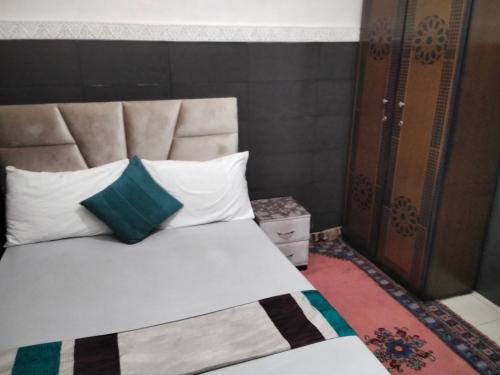 un lit avec des oreillers blancs et un oreiller bleu dans l'établissement DAR IJLAL, à Marrakech