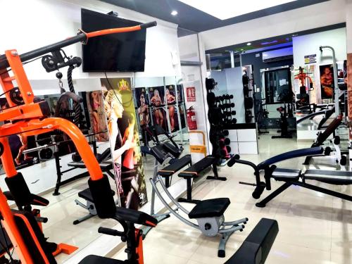 a gym with several tread machines and a flat screen tv at Hotel Adulam in Santa Cruz de la Sierra