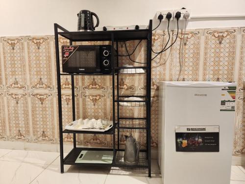 eine Mikrowelle auf einem Regal neben einem Kühlschrank in der Unterkunft مرافئ in Medina