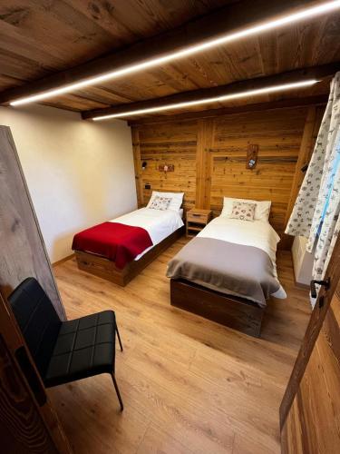 a room with two beds and a chair in it at Lo Boneur in Torgnon