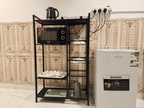 a microwave on a shelf next to a refrigerator at رفاه in Al Madinah