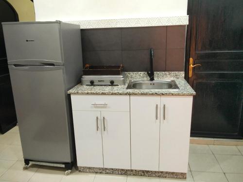 une petite cuisine avec un évier et un réfrigérateur dans l'établissement DAR IJLAL, à Marrakech