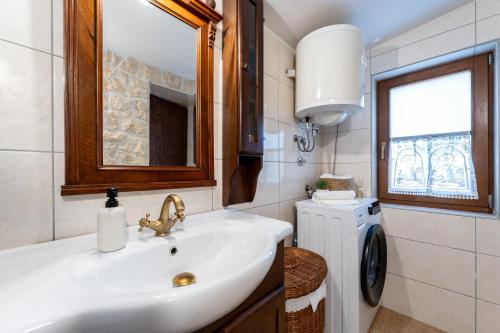 a bathroom with a sink and a washing machine at Villa Vidonjica in Novalja