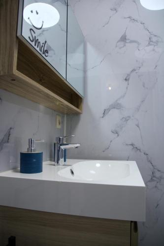 a white sink in a bathroom with marble walls at Aurelia in Zemst
