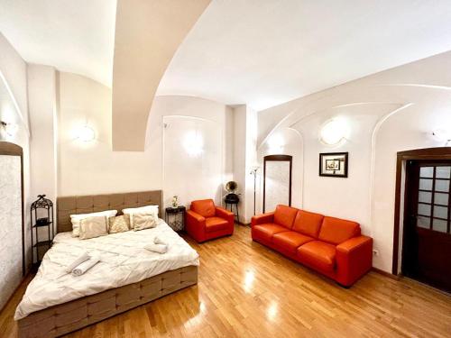 ein Schlafzimmer mit einem Bett und zwei orangefarbenen Stühlen in der Unterkunft Ada Old Town Apartments 3 in Braşov
