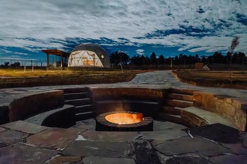 a fire pit in front of a domed observatory at Enxe Glamping & Spa 
