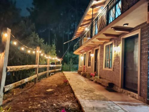 a building with lights on the side of it at night at Cabañas Ticomulco in Zacatlán