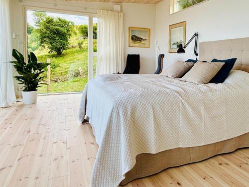 a bedroom with a large bed and a large window at Gåsviken - Hven in Sankt Ibb