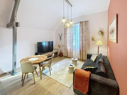 een woonkamer met een bank en een tafel bij T2 rénové au coeur de Vendôme avec parking - Le Kozy in Vendôme