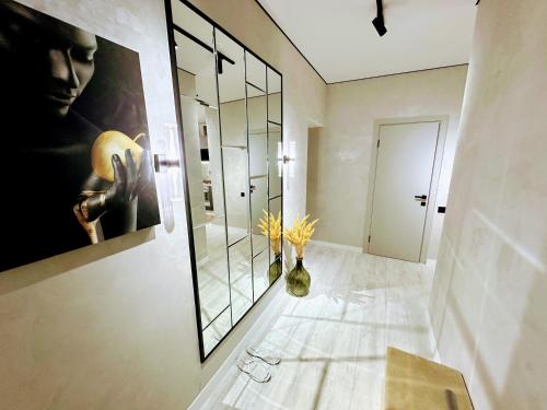 a bathroom with a large mirror and a vase with flowers at Нові стильні апартаменти в центрі in Mykolaiv