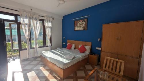 Un dormitorio con una cama y una pared azul. en The Bran Saga, en Haripūr