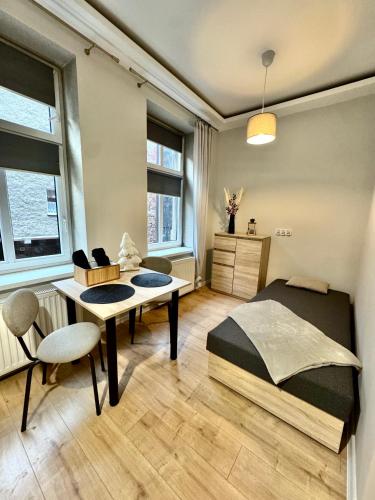 ein Schlafzimmer mit einem Bett, einem Schreibtisch und einem Tisch in der Unterkunft Pokój przy Parku Róż II in Chorzów