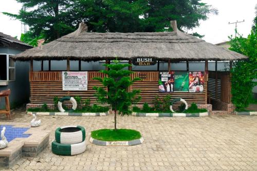 una pequeña cabaña con un árbol delante de ella en Tracer Wave Cabin, en Akwanga