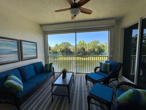 un salon avec un canapé et des chaises et une grande fenêtre dans l'établissement Fully Remodeled Two Bedroom Condo with shared pool, à Pine Ridge Helistop