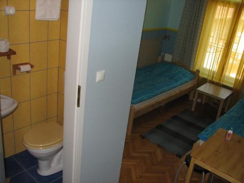 a small bathroom with a bed and a toilet at 7x24 Central Hostel in Budapest