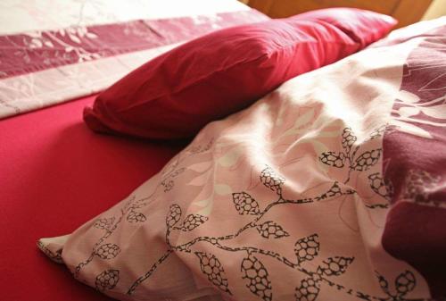 ein Bett mit einer Decke und zwei Kissen darauf in der Unterkunft Traditionelles Steinhaus mit Innenhof und Terrasse im Zentrum von Medulin, nicht weit vom Strand entfernt in Medulin