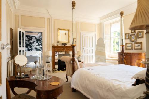 a bedroom with a bed and a table and a desk at The Bentley Suite in Gileston