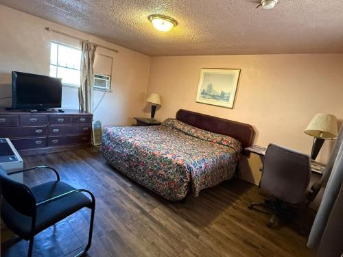 a bedroom with a bed and a flat screen tv at Springs Inn by Capital O I 25 in Colorado Springs