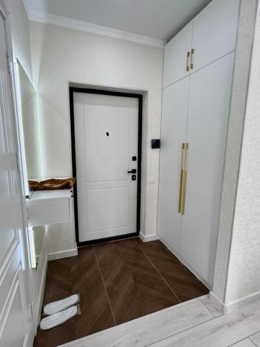 a hallway with a white door and a tile floor at ЖК Арман кала 1- комнатная квартира in Zhezdi