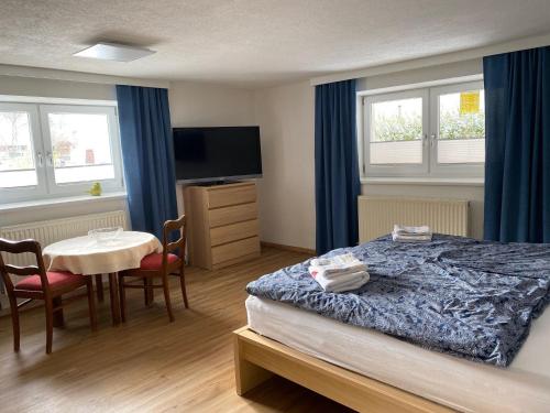 Una habitación de hotel con una cama y una mesa con sillas. en Modern Gemütlich, en Pflach