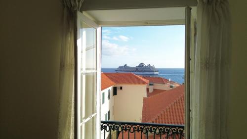 a window with a cruise ship in the ocean at Mirasol Guesthouse in Funchal