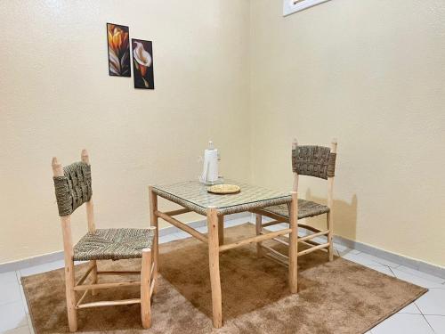 a table and two chairs sitting next to a table and a table and chairs at Residence Diar Kisane in Marrakech