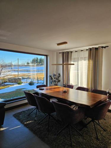 a dining room with a table and chairs and a large window at Cabana Stil in Mărişel