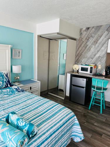 a bedroom with a bed and a microwave on a counter at Daytona Inn Beach Resort Step Outside and Put Your Feet in the Sand Beach Vibes in Daytona Beach
