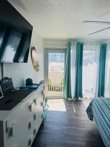 a kitchen with a sink and a bedroom with a window at Daytona Inn Beach Resort Step Outside and Put Your Feet in the Sand Beach Vibes in Daytona Beach