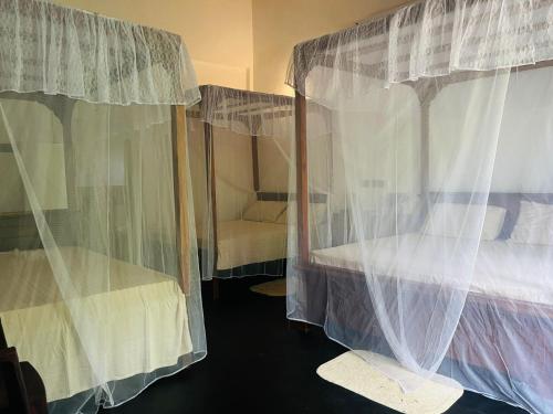 a bedroom with two bunk beds with curtains at Mashi's Villa in Sigiriya
