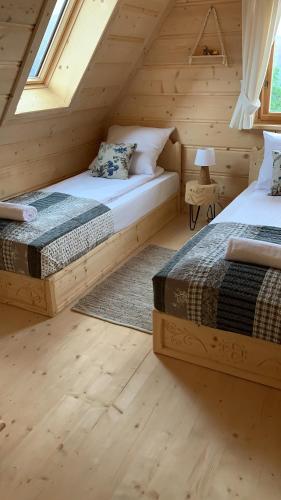 a bedroom with two beds in a wooden cabin at Ostoja Spokoju in Kościelisko