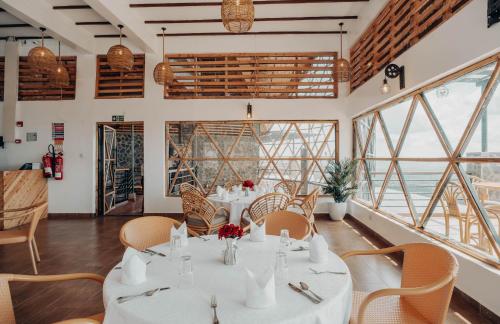 een eetkamer met tafels en stoelen en ramen bij Kitonga Garden Resort in Kangundo