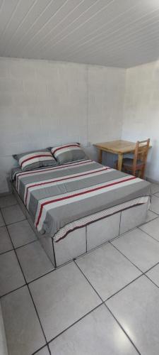 a large bed in a room with a table at Pousada Gaúcha Caibi in São Domingos