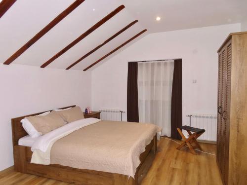 a bedroom with a large bed and a window at Chez Vila in Prizren