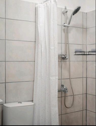a bathroom with a shower with a white shower curtain at Guest house by the river in Simitli