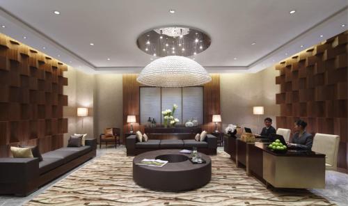 a lobby of a hotel with people sitting at desks at Mission Hills Hotel Resorts Dongguan in Dongguan