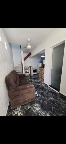 un soggiorno con divano marrone in una camera di Marea Home ad Arraial do Cabo